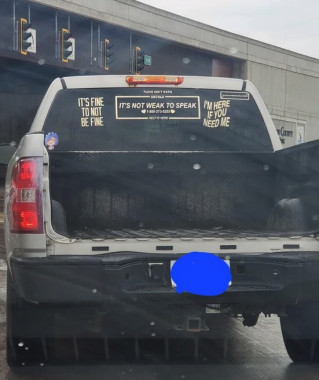 A pick-up truck with stickers on the back window bearing messages like "It's fine to not be fine", "It's not weak to speak", and "I'm here if you need me".