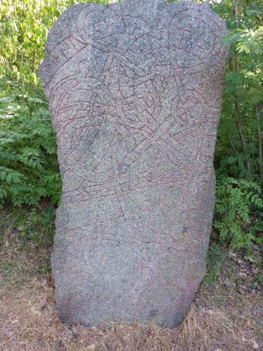 Runestone in a shadowy spot in a park.