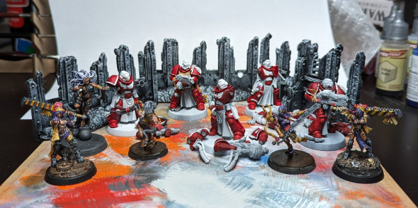Warhammer 40k Space Marine Strenguard Veterans with some red paint, sisters of battle Repentia in purple with hazard stripe chainswords, a possessed breaking free of if her chains, and three ruined walls painting black and dry brushed white.