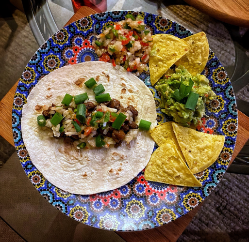 A photo of my homemade vegan tacos and guacamole on a colourful Moroccan plate