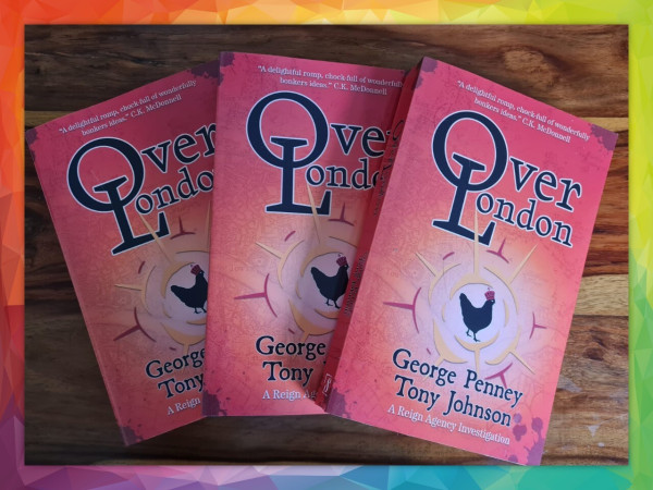 You're looking at three paperback copies of the comic fantasy whodunnit OverLondon, one of which may be yours in a matter of days! The books are a delightful orange and feature the words "OverLondon" and the author names "George Penney and Tony Johnson". There is an irate looking chicken depicted in the middle of the cover wearing a crown. The chicken orders you to enter this competition, because why not?!