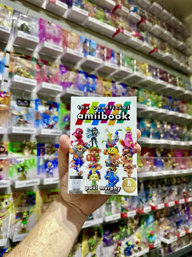 The Unofficial Amiibook held up against a wall of sealed Amiibo