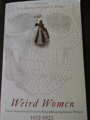 Cover of Weird Women: Classic Supernatural Fiction by Groundbreaking Female Writers, 1852-1923, edited by Lisa Morton and Leslie S. Klinger. A woman, face turned away, in a black and white dress with a small umbrella, walks across a pointilist skull.