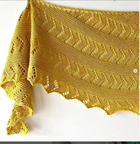 A crescent-shaped shawl made from one skein of sock-weight yarn. Sections of garter stitch are followed by sections of simple diagonal lace. Sample is knitted in mustard colour.