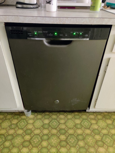 It's just the photographer's GE dishwasher. On the green linoleum floor, below the bottom left corner of the dishwasher door, sits a small plastic cup to catch the latest leak.