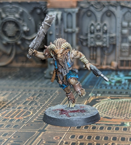 A gnarly part-man/part-goat Warhammer 40k beastman miniature painted up with browns and Metallica with turquoise accents because he's fancy like that.