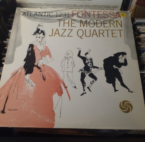 Album cover features an illustration of a woman in an old style of dress, with three figures in the background, including a jester and.. a pastry chef?
