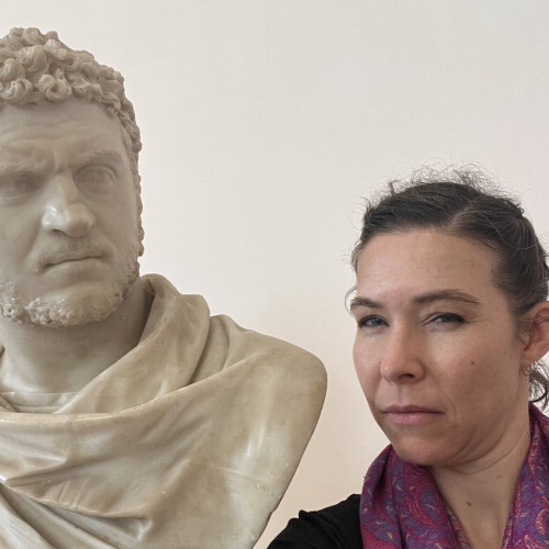 Dr G frowning while standing next to a bust of Caracalla.
