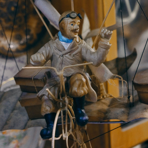 Close of a vintage toy of a man pedalling a bicycle.