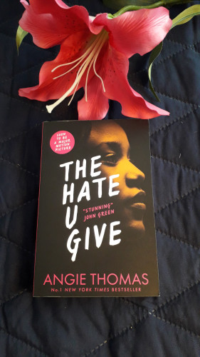 The cover of The Hate U Give.
Highlighted by a mate black background, the profile of a young African American presents us with the impression of her strength as she looks ahead, perhaps into the future.
The title, on white bold letters, sets at the forefront, with a quote from John Green, "Stunning" nesting in between.
