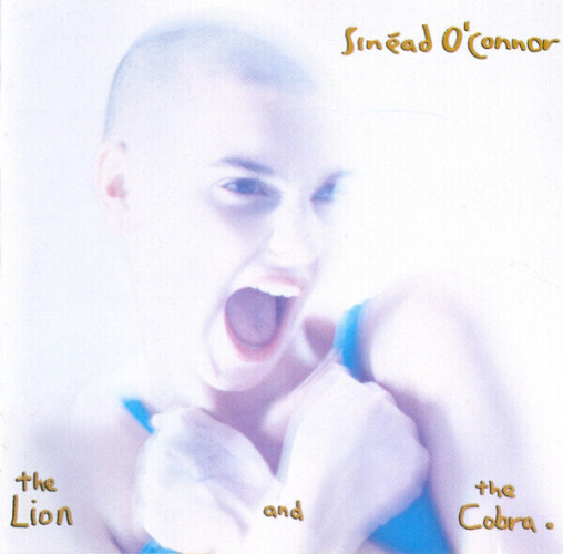 The cover of Sinéad O'Connor's album The Lion and the Cobra. It shows Sinéad singing, her expression defiant, her head shaved, her hands in fists crossed over her chest. The image is bleached and slightly blurry, the background white.