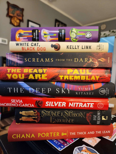 A stack of books. The titles, from the top down, are: Veniss Underground; White Cat, Black Dog; Screams from the Dark; The Beast You Are; The Deep Shy; Silver Nitrate; A Strange and Stubborn Endurance; The Thick and the Lean