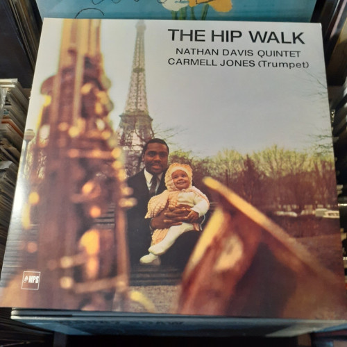 Album cover features a photograph of Nathan Davis and his baby daughter.  In the foreground, a blurry saxophone is seen; in the background, the Eiffel Tower.