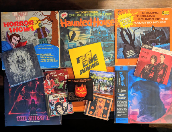 Picture of various spooky records & CDs:
-Records: an old-tyme collection of radio HORROR SHOWS, 2 different versions w/ different sounds on each of Disney's THRILLING, CHILLING SOUNDS OF THE HAUNTED HOUSE, THE GUEST & SUSPIRIA soundtracks. -45 records of THE SHINING score, Cadabra Records MACABRIA, a TWIN TEMPLE single 
-CDs of BLACK HALLOWEEN, the ELECTRIC HELLFIRE CLUB's Halloween album, The Haunted Mansion ride narration & music, the ROCKY HORROR PICTURE SHOW soundtrack and a mix CD I made of various movie horror themes & spooky music. Whew.
