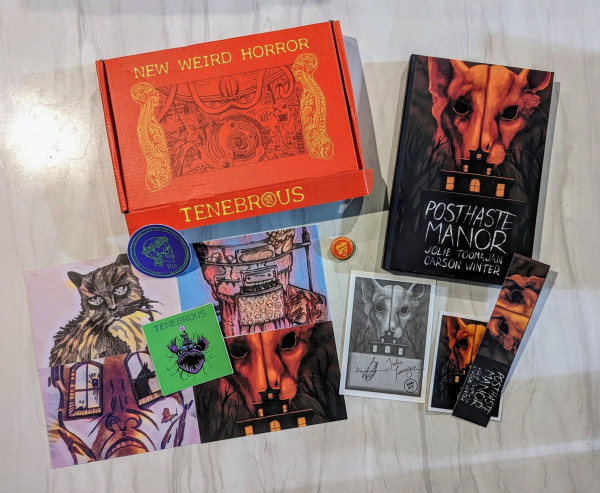 Hardcover of POSTHASTE MANOR with an assortment of goodies: stickers, a pin, art prints, a bookmark, and a signed bookplate