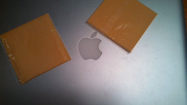 A visual pun of a Mac laptop with two slices of American "cheese" stuck to it... making it a Mac & Cheese..
