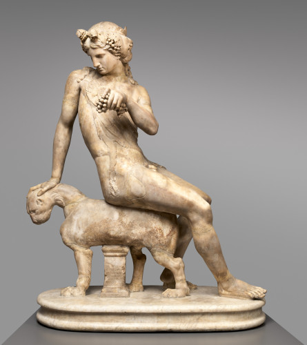 Marble sculpture of Dionysos riding his pet panther. The god sits on the panther's back, one hand on her head. He holds a cluster of grapes in his free hand. His long hair is adorned with a grapevine crown and he is wearing an animal skin.