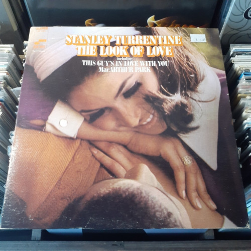 Album cover features a photo of a smiling woman resting against the chest of a man. They appear to be lying on the grass in a park.
