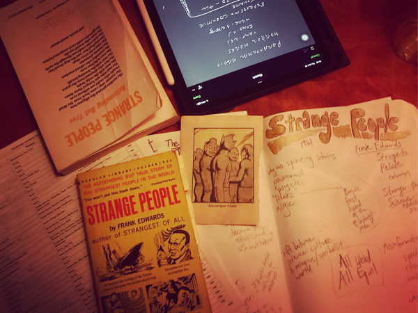 A pile of notebooks and copies of the book “Strange People” by Frank Edwards.