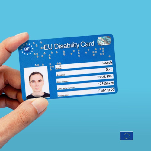 Hand showing the example of an EU Disability Card on blue background. On the card is written the fictitious name of Joseph Borg. Date of birth 01/01/1985. Card serial number 123456789. Expiration date 01/01/2027 
