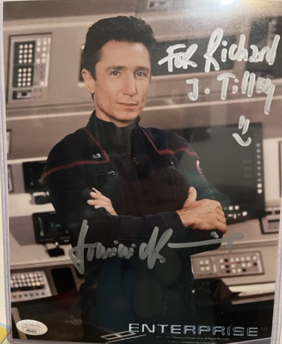 Dominic Keating's signed picture as Malcolm Reed. He is in uniform, standing arms crossed looking at the camera in a standard pose. His name is signed and his signed the picture to my name with a little happy face. 