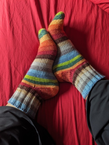 A pair of almost rainbow handknit socks in self striping yarn. 