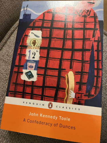 Front cover of A Confederacy of Dunces from the Penguin Classes collection featuring a drawing of a very large man in a checked shirt holding a hot dog.