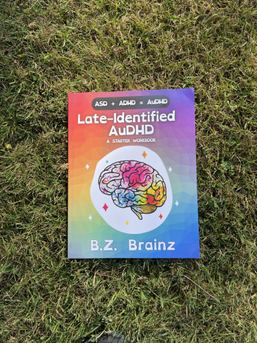 Late-Identified AuDHD: A Started Workbook in summer light on grass. 