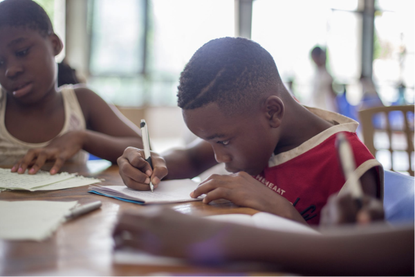 Young Black male child works on studies in class.