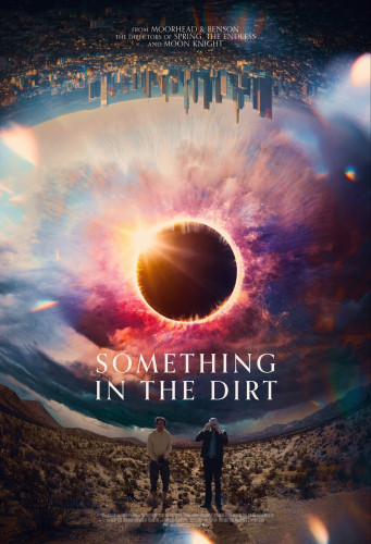 The poster for "Something in the Dirt". The two main characters stand toward the bottom in a desert with the title directly above them. The landscape wraps around so that a city looks above them upside-down. In the center is the sun during an eclipse. The effect looks something like an eye looking out of the poster