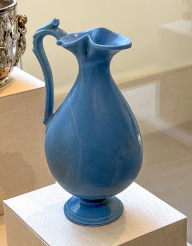 This very elegant semi-opaque pale blue glass oinchoe (jug), whose shape imitates that of a metal vessel, shows how quickly the newly founded Roman glass industry mastered its medium. It represents a transitional phase in glassmaking, when casting and cutting, and blowing techniques were used. The jug's handle was cold-carved and the base was cut on a lathe, but the body seems to have been blown. A similar combination of techniques is found on some examples of early Roman cameo glass, notably the British Museum's Portland Vase.

Gift of J. Pierpont Morgan, 1917
Met Museum