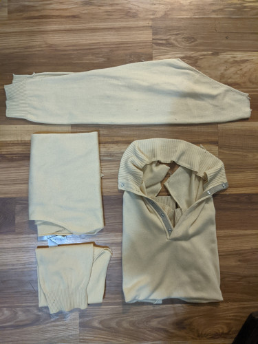 A butter yellow sweater that has been disassembled into parts