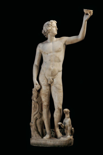 Marble statue of Dionysos. His hair is tied up and adorned with ivy or grapevine leaves. He is holding up a cup or bowl, likely filled with wine, high above his head. In his other hand he is holding a cluster of grapes. A panther is begging at his feet, raising her paw.
