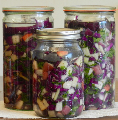 3 glass jars filled with chopped vegetable: green, white, red/purple andd some light yellow (the ginger).