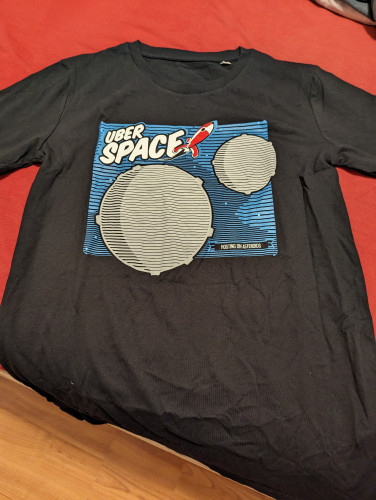 Ein schwarzes T-Shirt mit Aufdruck:
Uberspace
"Hosting on Asteroids"  
Eine rote Rakete fliegt von zwei Asteroiden weg.