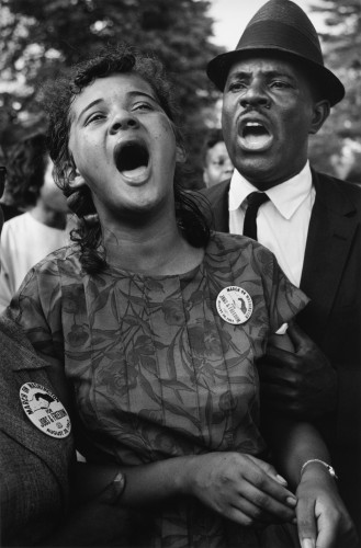 Black and white image of an ordinary man and woman singing at the 1963 march on Washington.