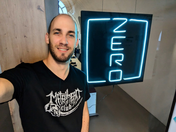 Picture of me wearing a black metalhead.club shirt. Next to me: ZERO GmbH entrance with large blue ZERO logo.