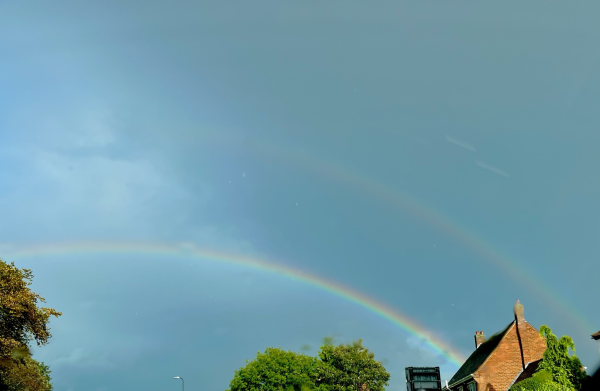Enhanced photo of a double rainbow over houses