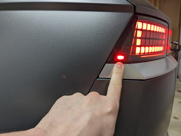 Me pointing to the rear side marker in the taillight module of the Ioniq 5. The light is about the same size as my index finger nail.