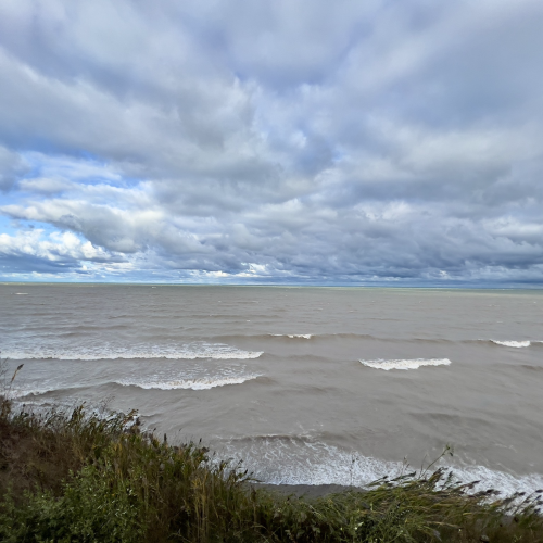Wide shot of Lake Michigan with waves crashing and dramatic clouds. 