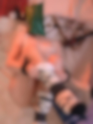 blurred pic of Poki. You can see they're on their back, legs up, with a bag on their head and big big wintery socks on their feet