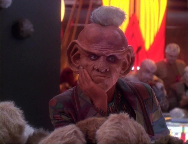 A shot of Quark surrounded by Tribbles, including one sitting on top of his head.