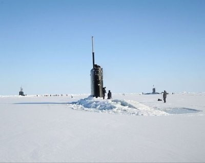 A picture of a submarine emerging in an ice cap.