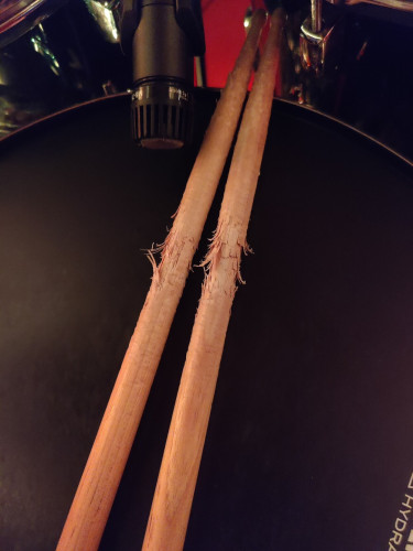 A pair of drumsticks with very deep grooves and wear marks