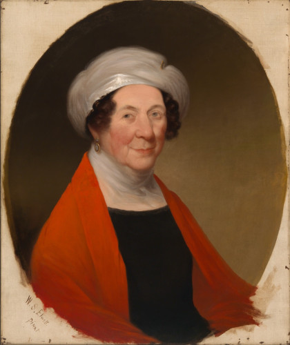 Painted portrait of First Lady Dolley Madison. She wears a bright red shawl, and a black top with a white, sheer fabric wrapped around her neck. A single black and gold earring is visible on her left ear. Her brown hair hangs in short, ringlet curls from under her white hat. Her face is stern with a slight upturn at the corner of her mouth. She looks directly at the viewer. 