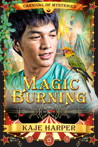 Cover - Magic Burning by Kaje Harper - a handsome young asian man, posibly Japanese, in a light blue t-shirt, staring at a bird on his shoulder, a ferris wheel and curcus tent behind him