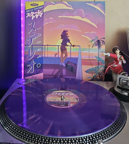 A purple splatter vinyl record sits on a turntable. Behind the turntable, a vinyl album outer sleeve is displayed. The front cover shows an anime girl on a balcony resting her hands on a railing overlooking a sunset, beach, and street. 

To the right of the album cover is an anime figure of Yuki Morikawa singing in to a microphone and holding her arm out. 