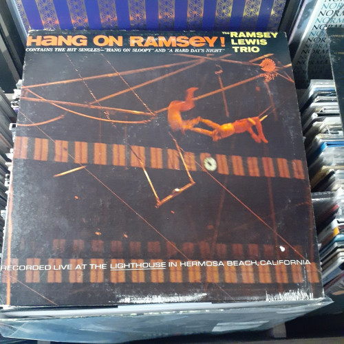 Album cover features a photograph of trapeze performers flying through the air with the greatest of ease.