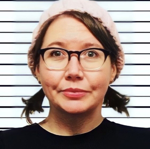 Photoshopped mugshot of an awkward woman in glasses and pigtails wearing a pink knit cap