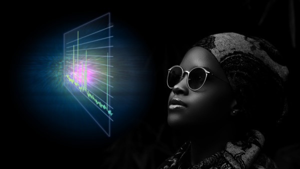 An African lady in a dark room. She is looking up towards a holographic projection of an NMR spectrum